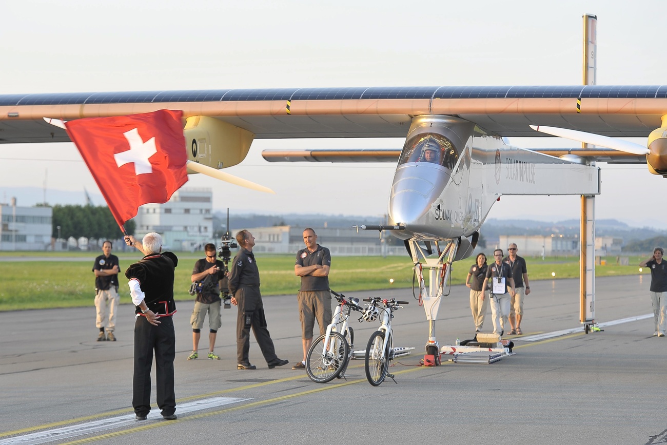 bertrand piccards flugzeug wird von einer schweizer flagge begrüsst