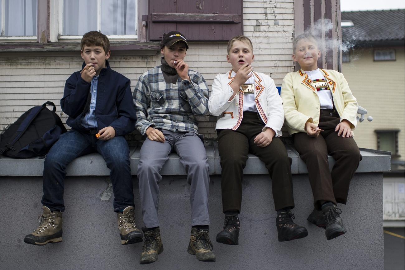 Swiss boys having a smoke at a traditional cattle show