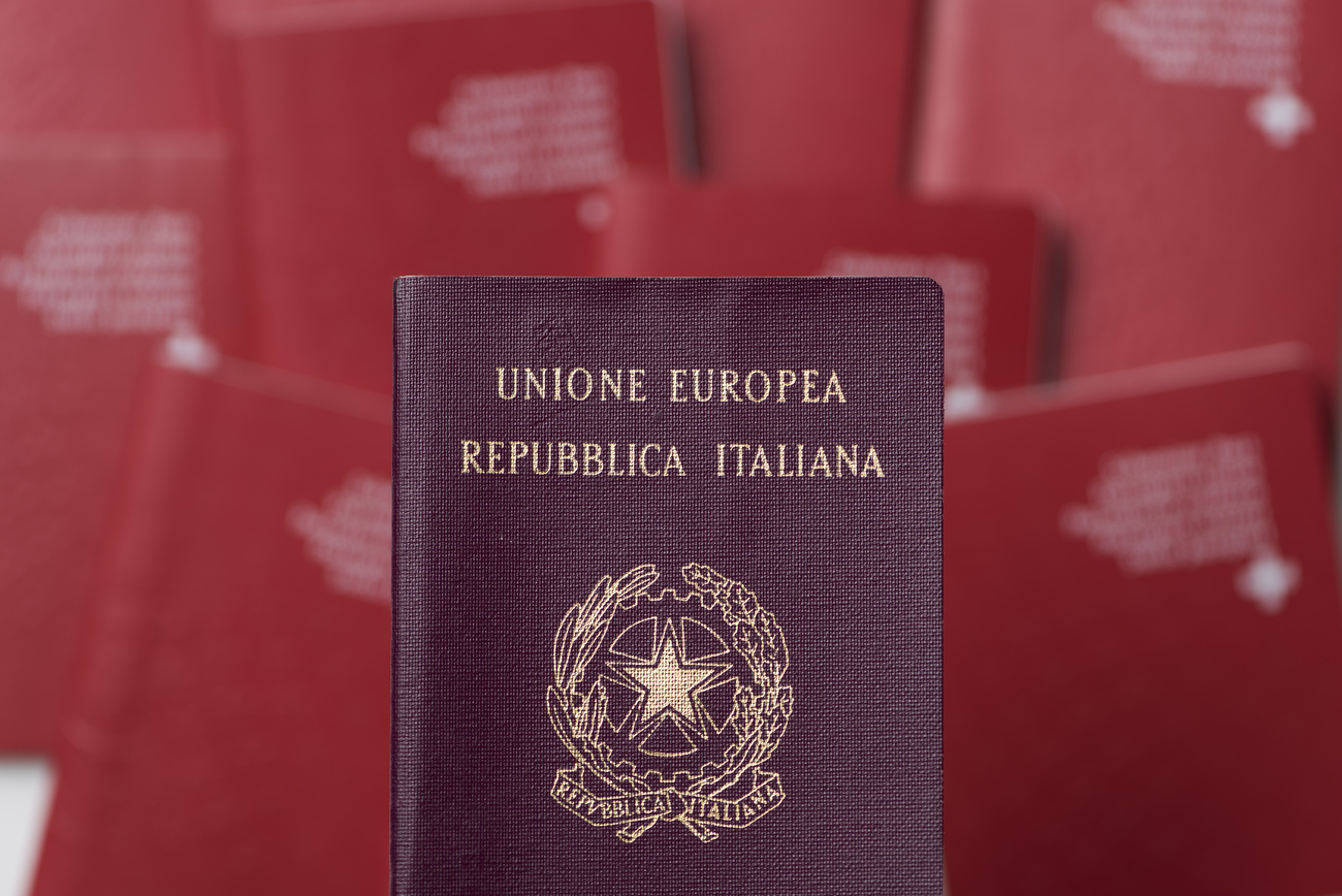 dunkelroter italienischer Pass über roten Schweizerpässen