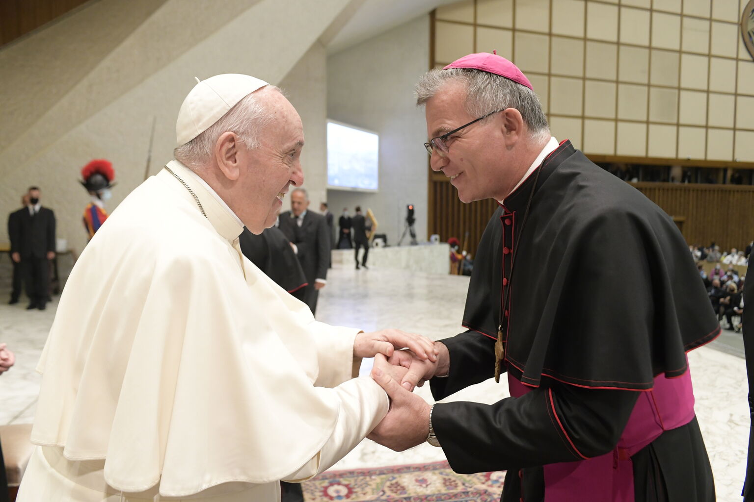 Papst Franziskus begrüsst einen Bischof.