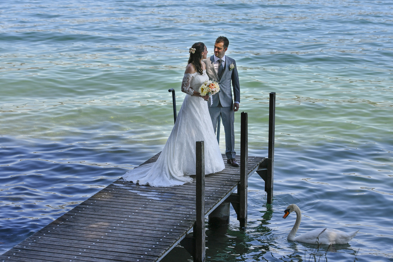 Coppia di sposi per la foto ricordo in riva a un lago.