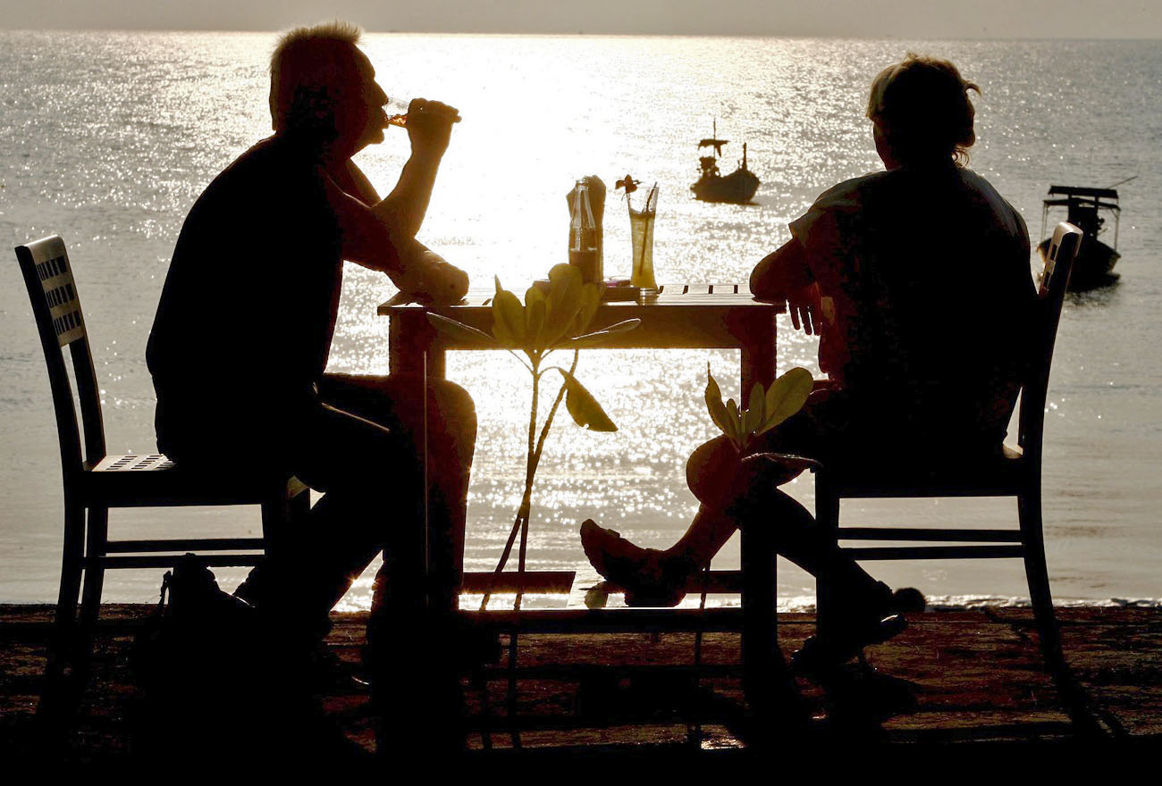 Couple assis buvant l apéro en bord de mer