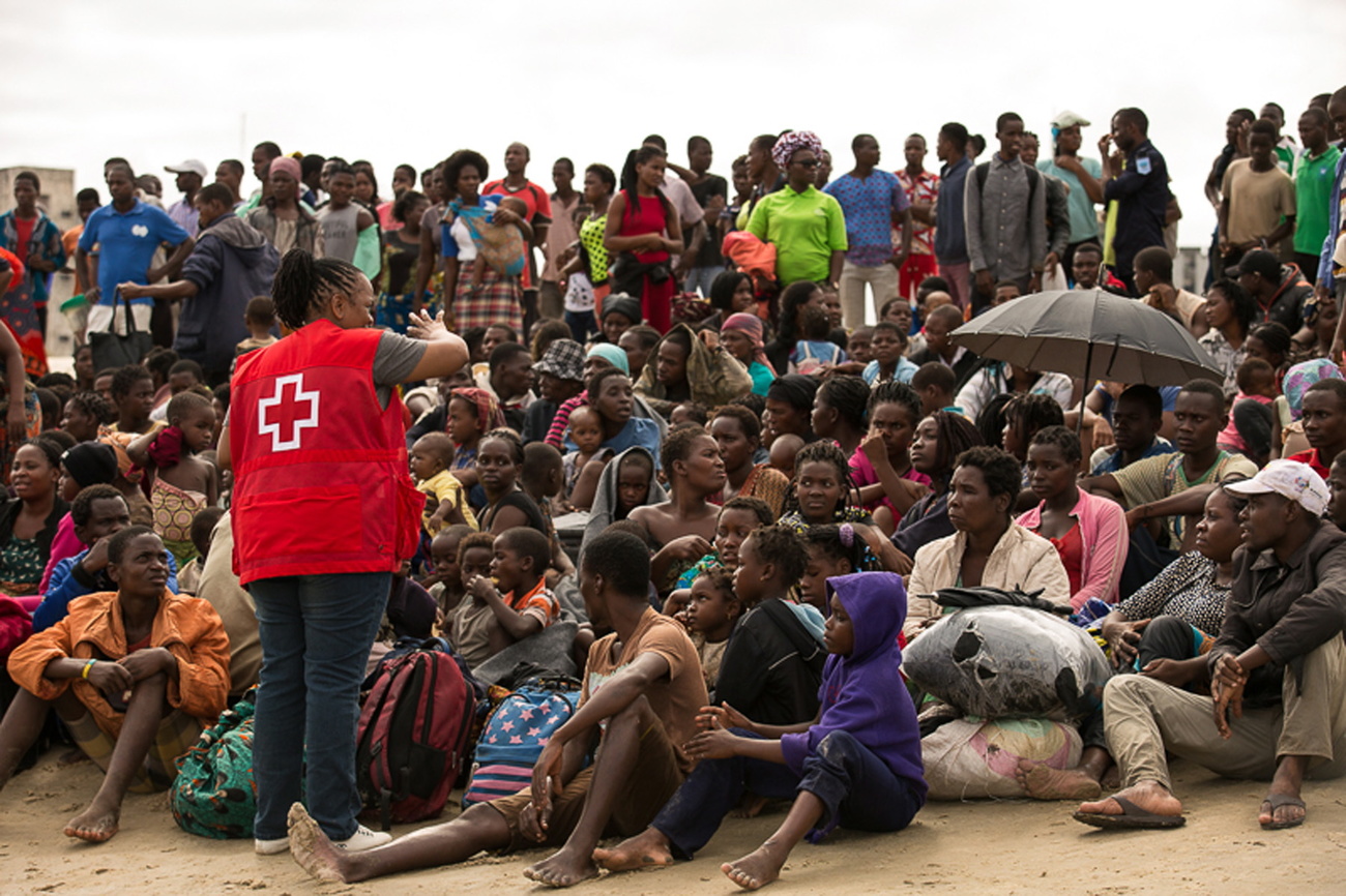 Eine Frau vom IFRC steht vor einer Menge.