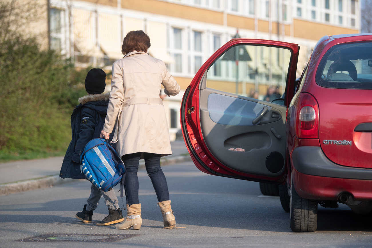 Eine Mutter begleitet ihr Kind zur Schule