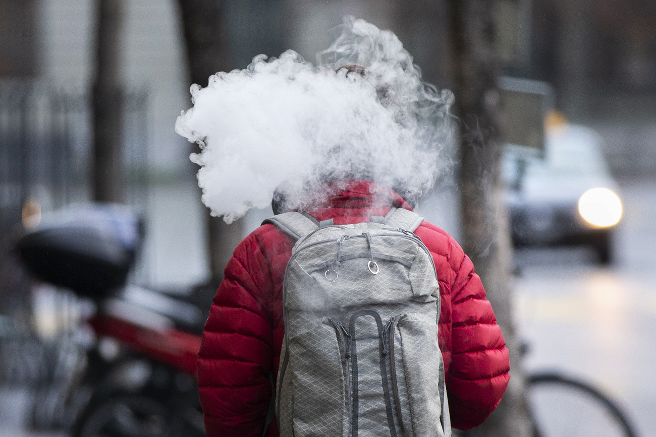 persona con testa avvolta nel fumo di una sigaretta elettronica