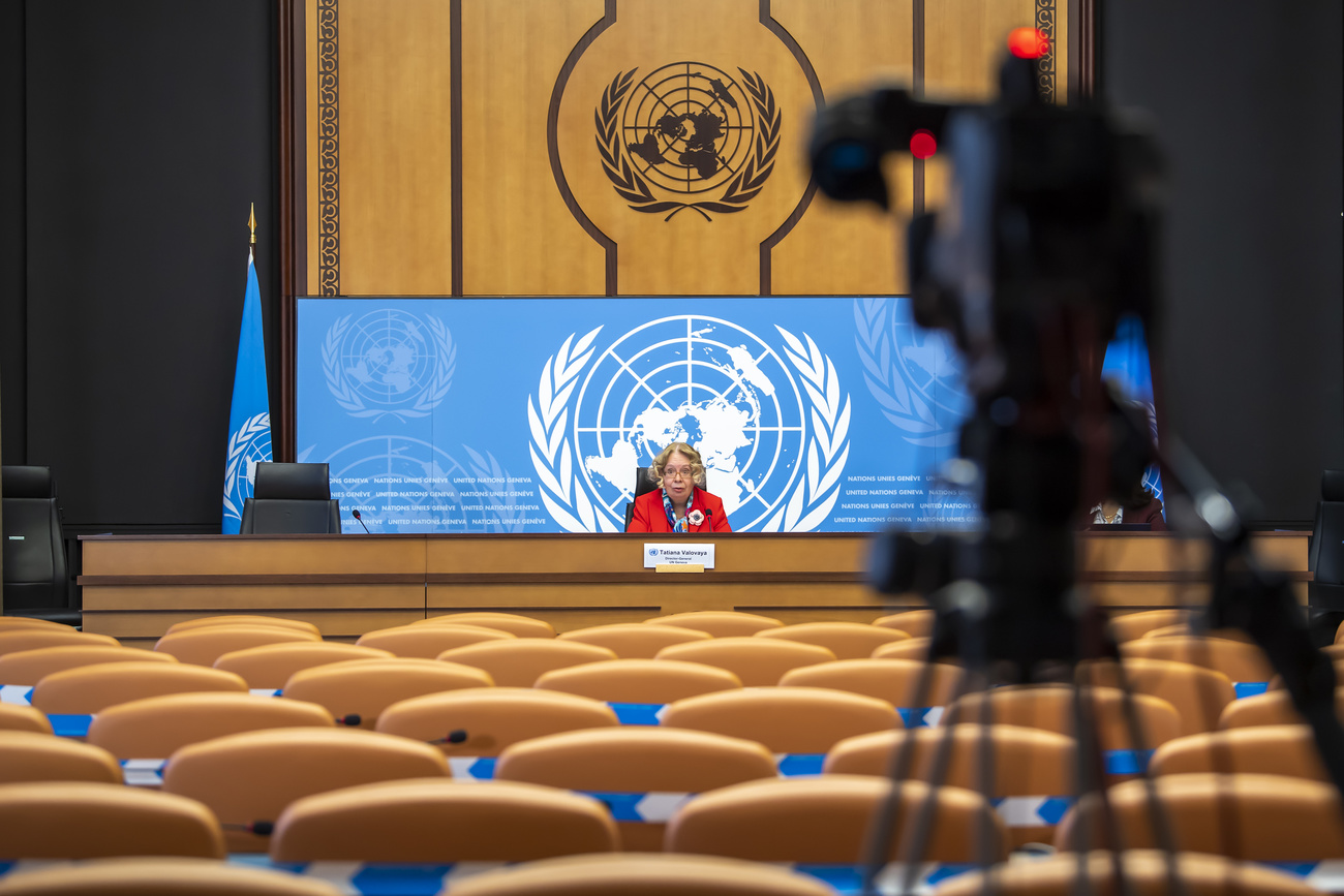 Picture of empty UN conference room with woman speaking at table