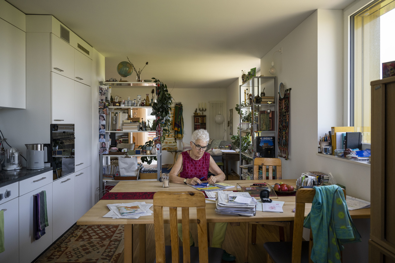 An old woman sits at a table.