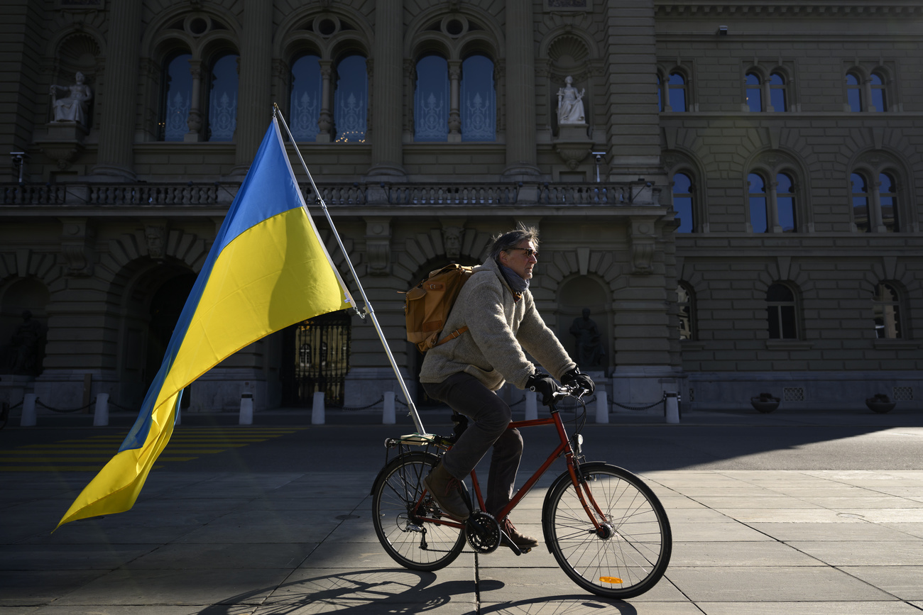 Ein Mann auf einem Fahrrad mit einer ukrainischen Flagge