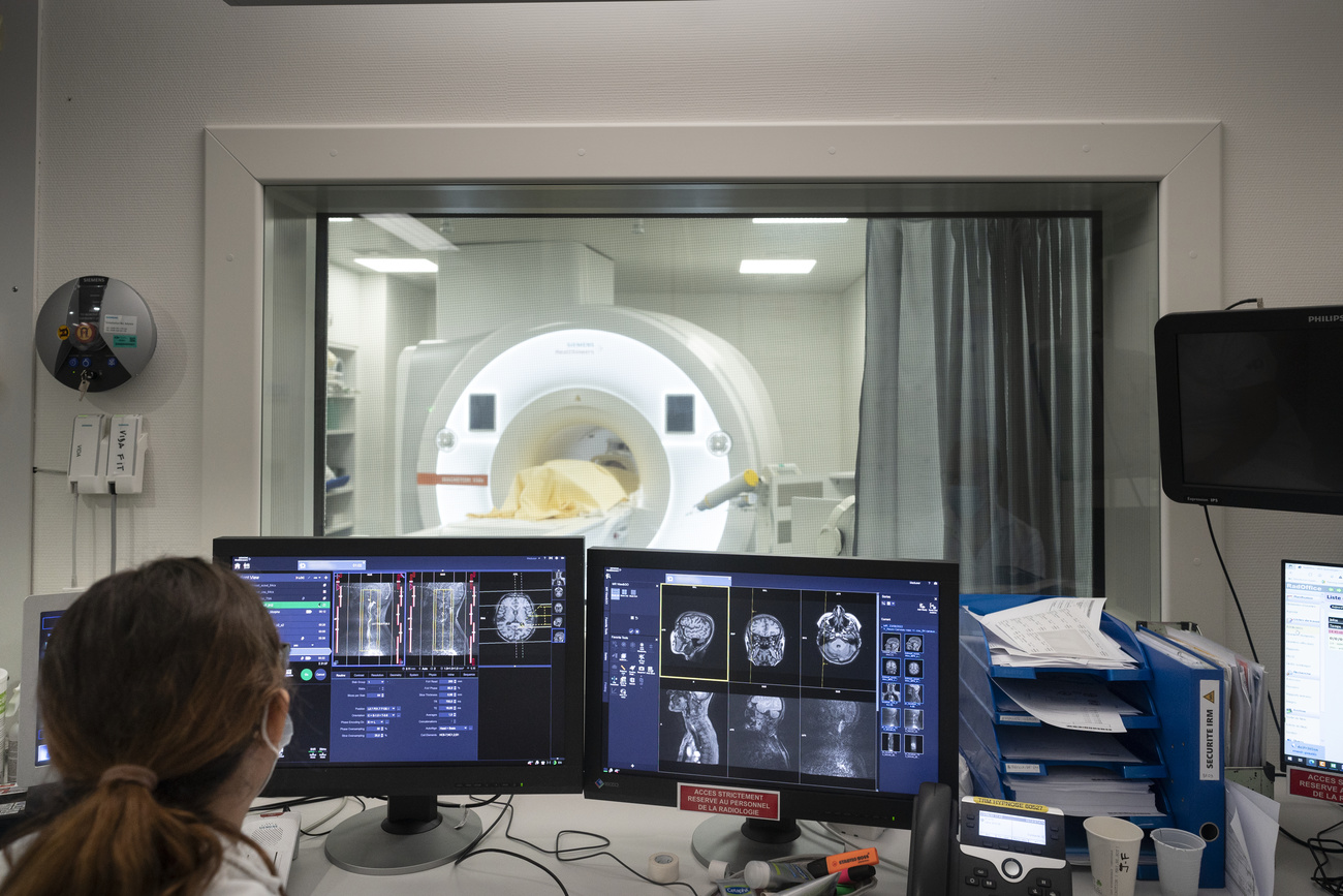 Bildschirme mit Aufnahme aus dem MRI-Gerät im Hintergrund