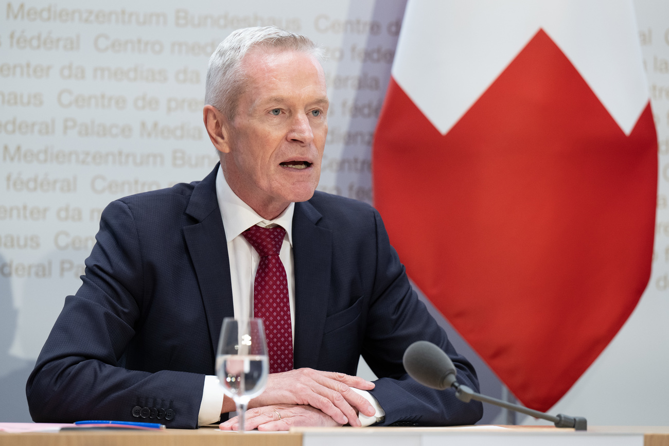 Federal Electricity Commission (ElCom) President Werner Luginbühl in front of swiss flag at a press conference