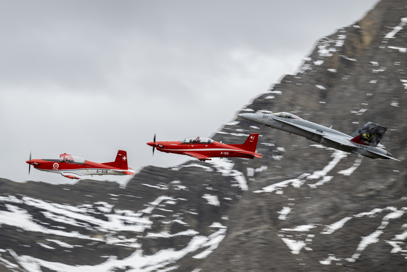 drei militärische Flugzeuge fliegen in Formation vor einem Berg