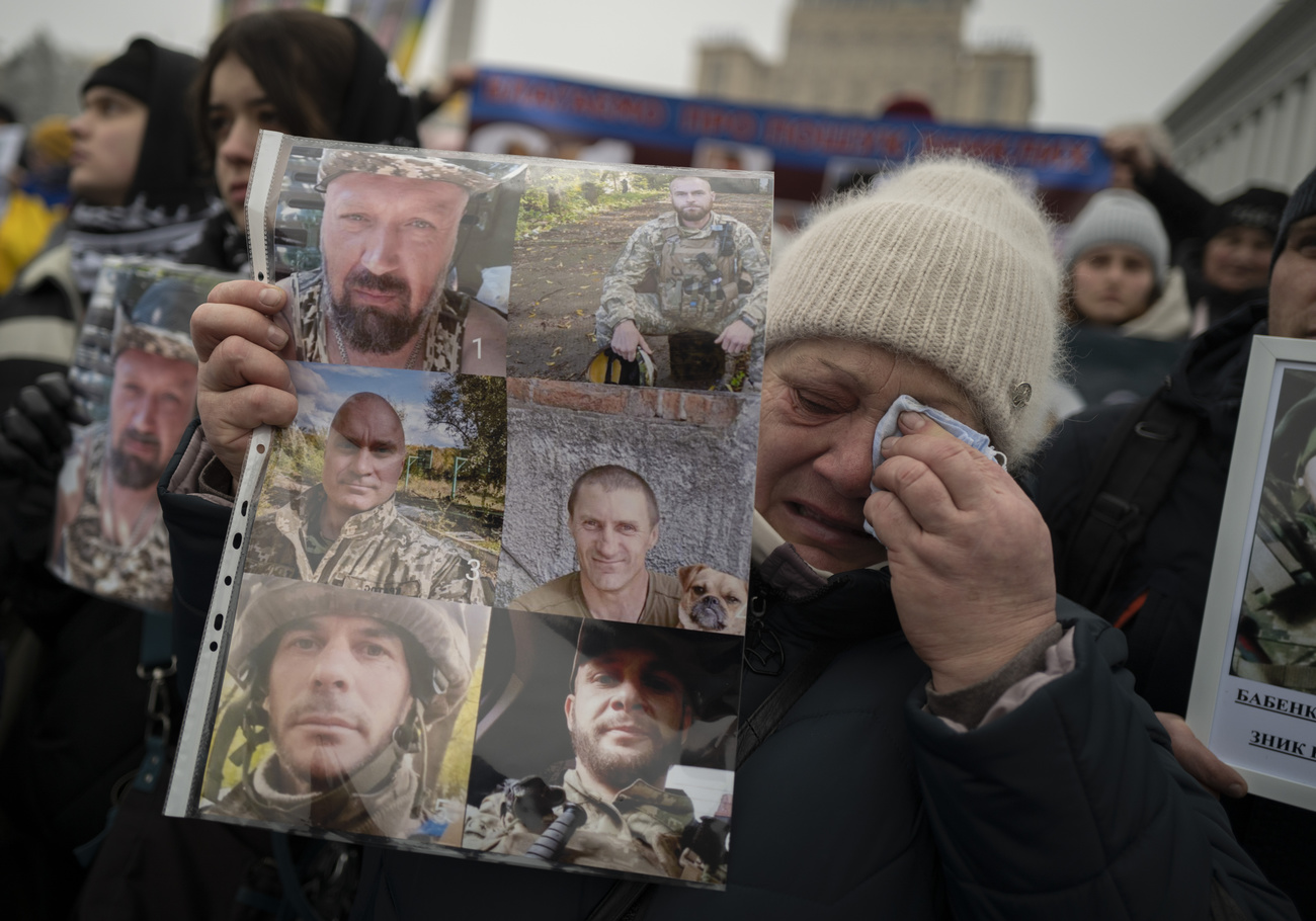 2023年1月14日，在乌克兰基辅市中心举行的示威活动上，一位母亲手举失踪儿子米及其战友的照片。