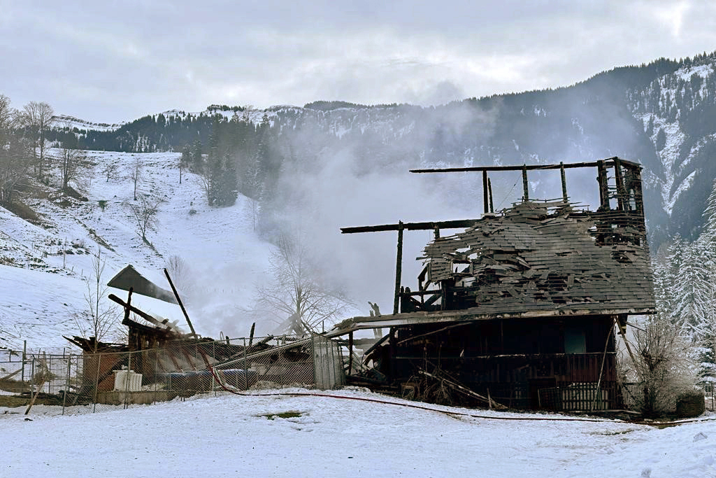 macerie fumanti di una casa in paesaggio innevato