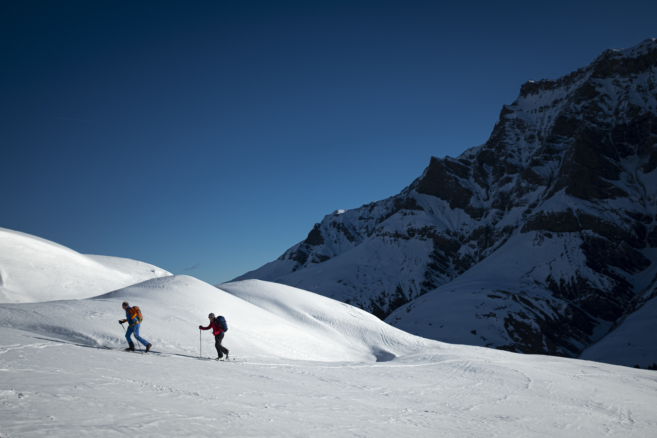 swiss skiers on snow mountain trail