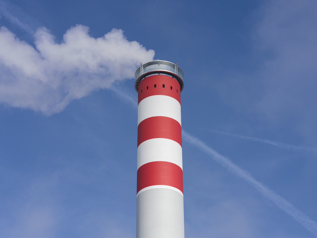 fumo esce da ciminiera industriale bianca e rossa