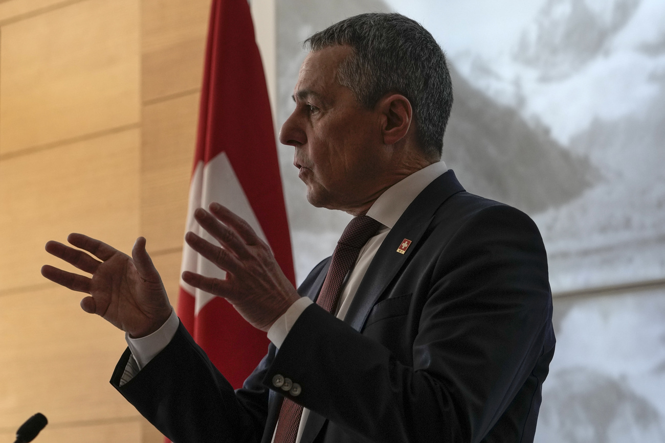 Immagine di un uomo che parla con la bandiera svizzera sullo sfondo