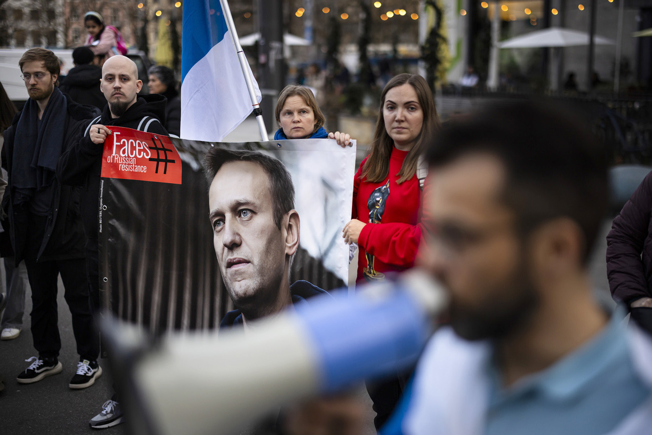 Menschen halten ein Plakat mit einem Porträt des russischen Oppositionsführers Alexej Nawalny.