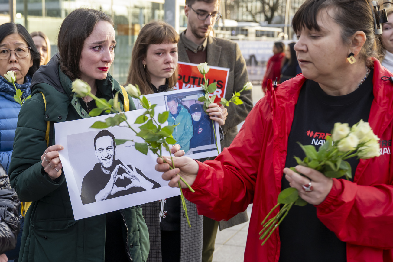 Pessoas choram segurando cartaz de Navalny