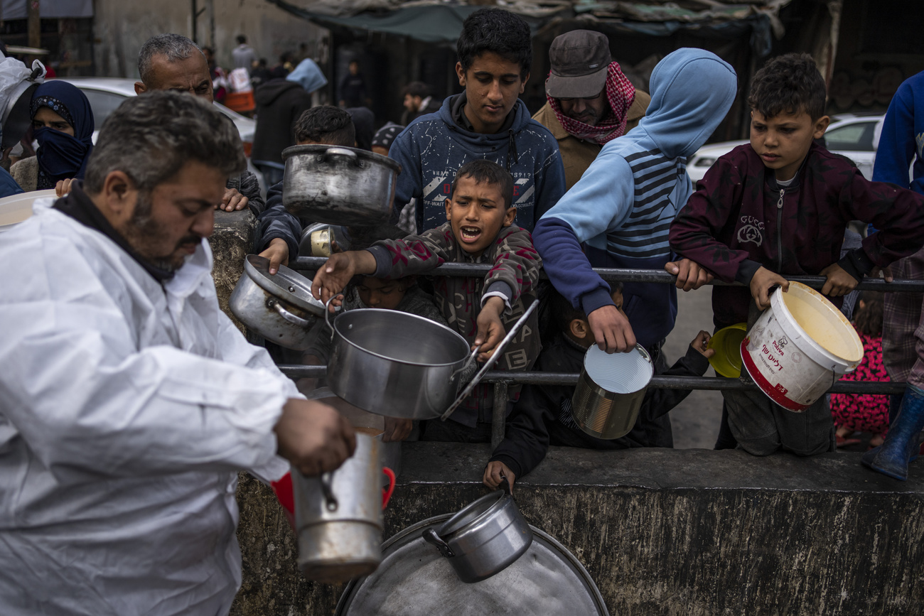 Civili che chiedono cibo a Rafah