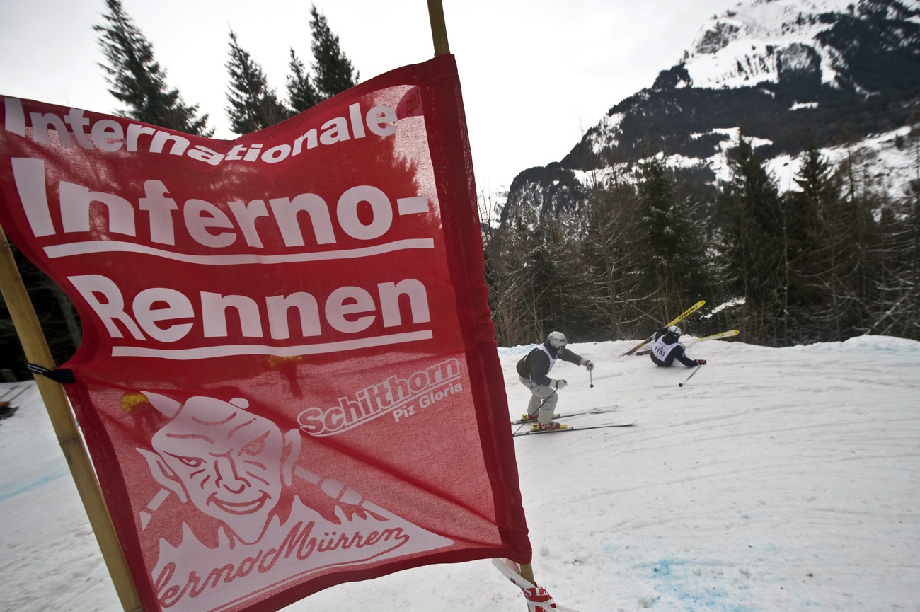 Renn-Tor des Inferno-Skirennens, im Hintergrund zwei Skifahrer, von denen einer in einer Kurve stürzt
