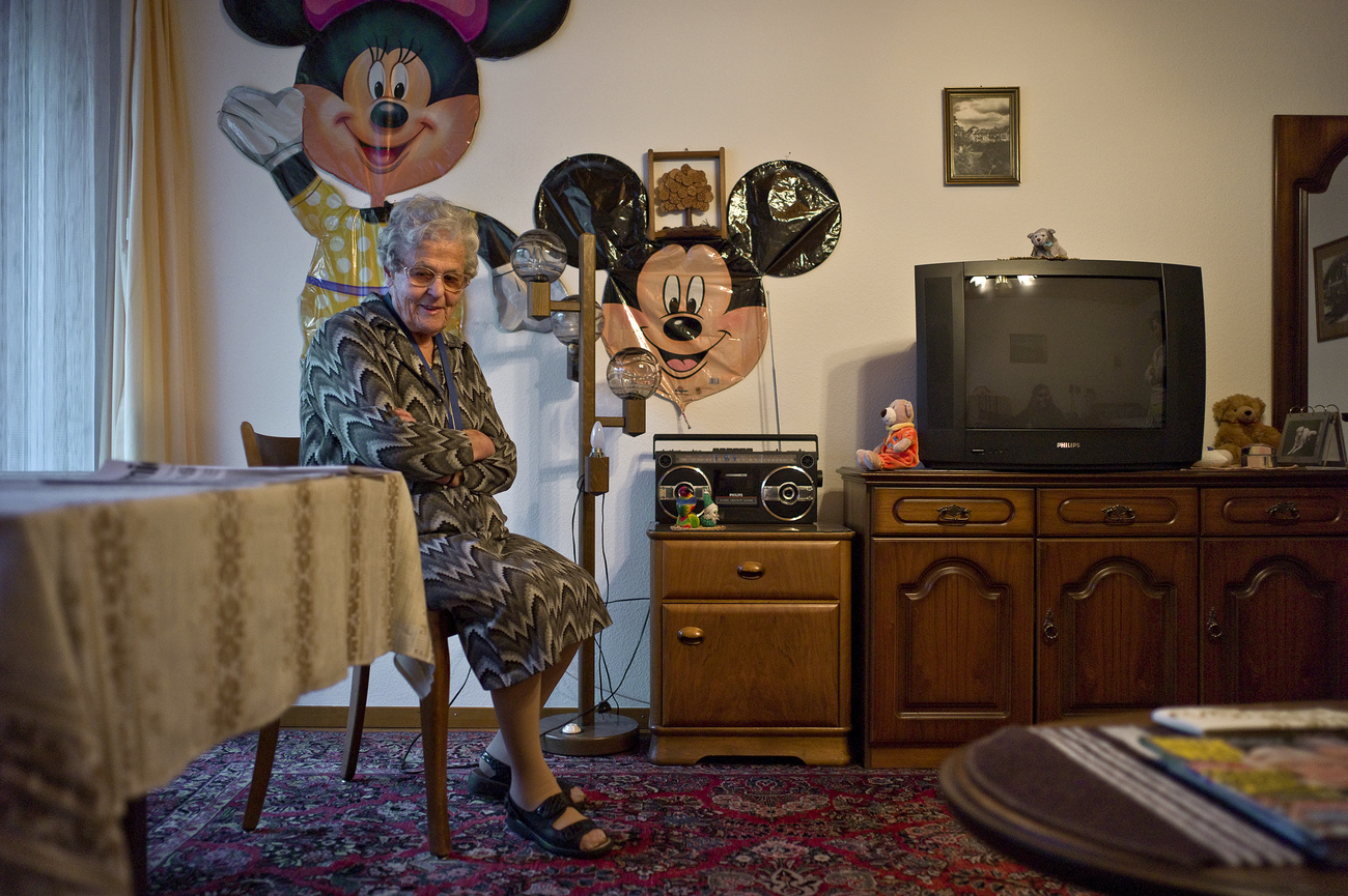 Femme âgée assise dans son appartement.