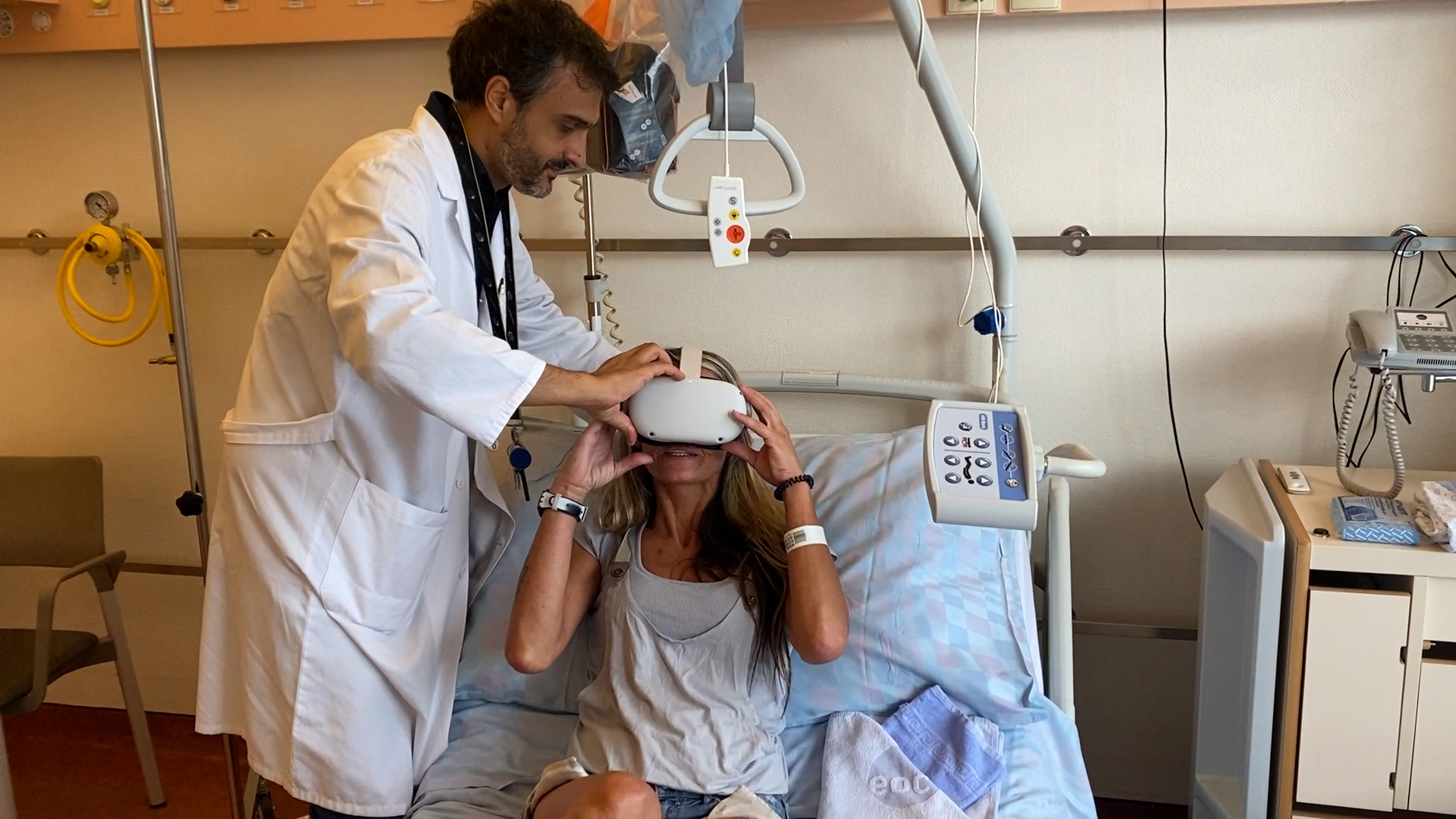 Arzt in einer Klinik hilft einer Patientin, eine Virtual-Reality-Brille aufzusetzen