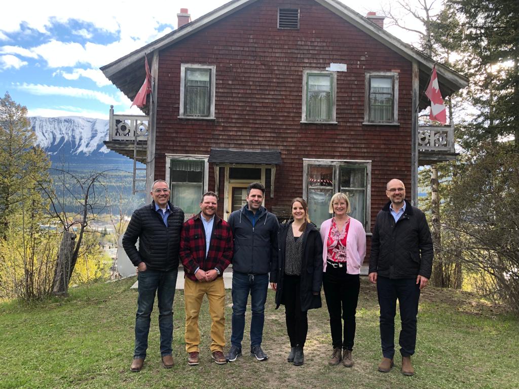 Männer und Frauen vor einem Chalet in Kanada