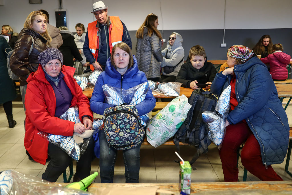 Refugees wait for a bus in Poland to take them to Switzerland.