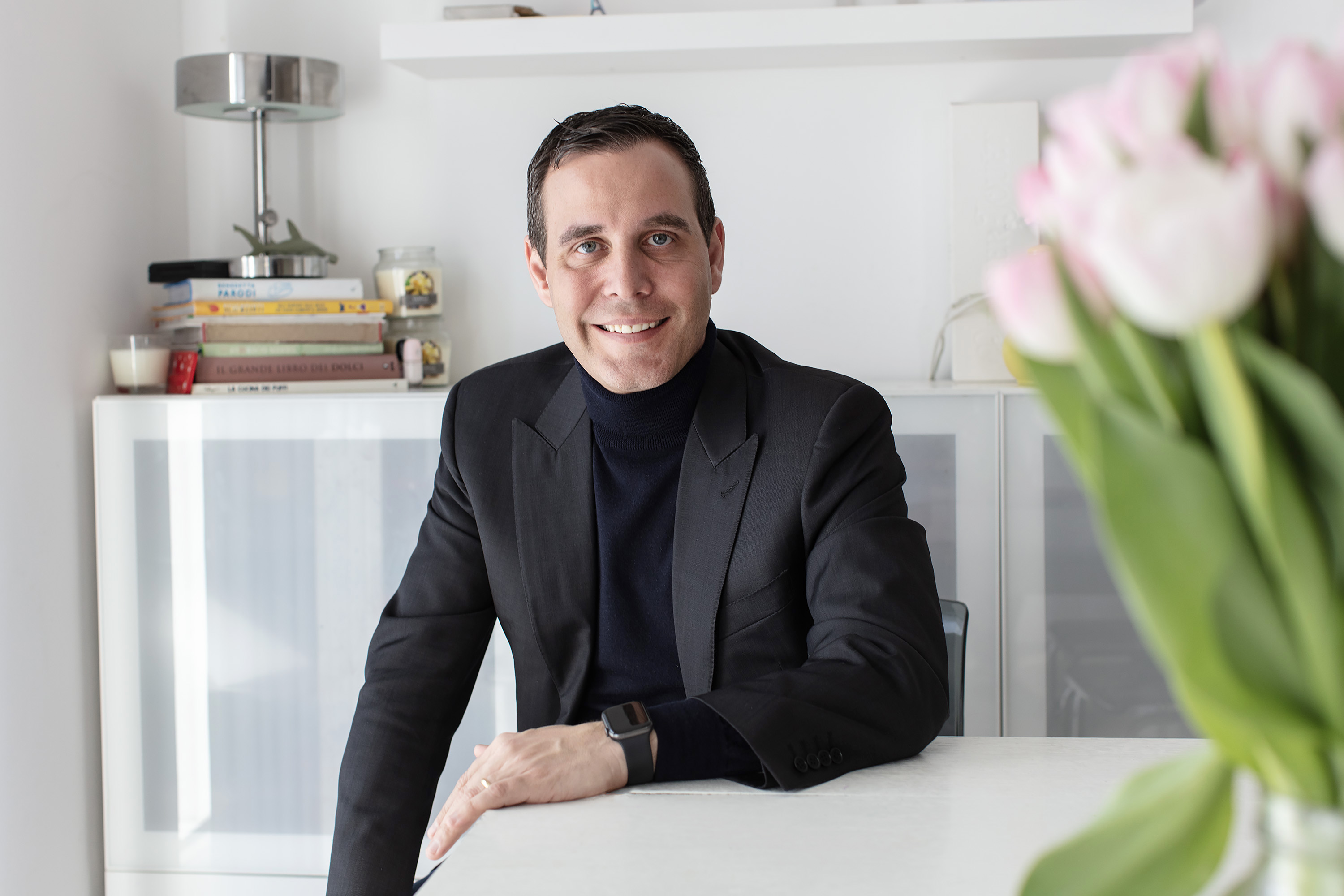 Homme posant assis dans son bureau.