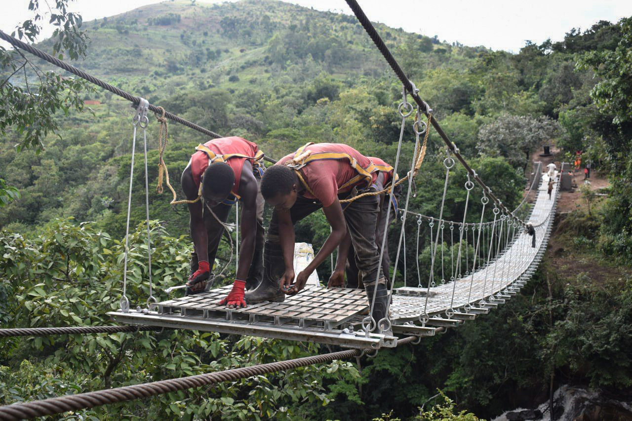 Zwei Männer bauen an einer Hängebrücke