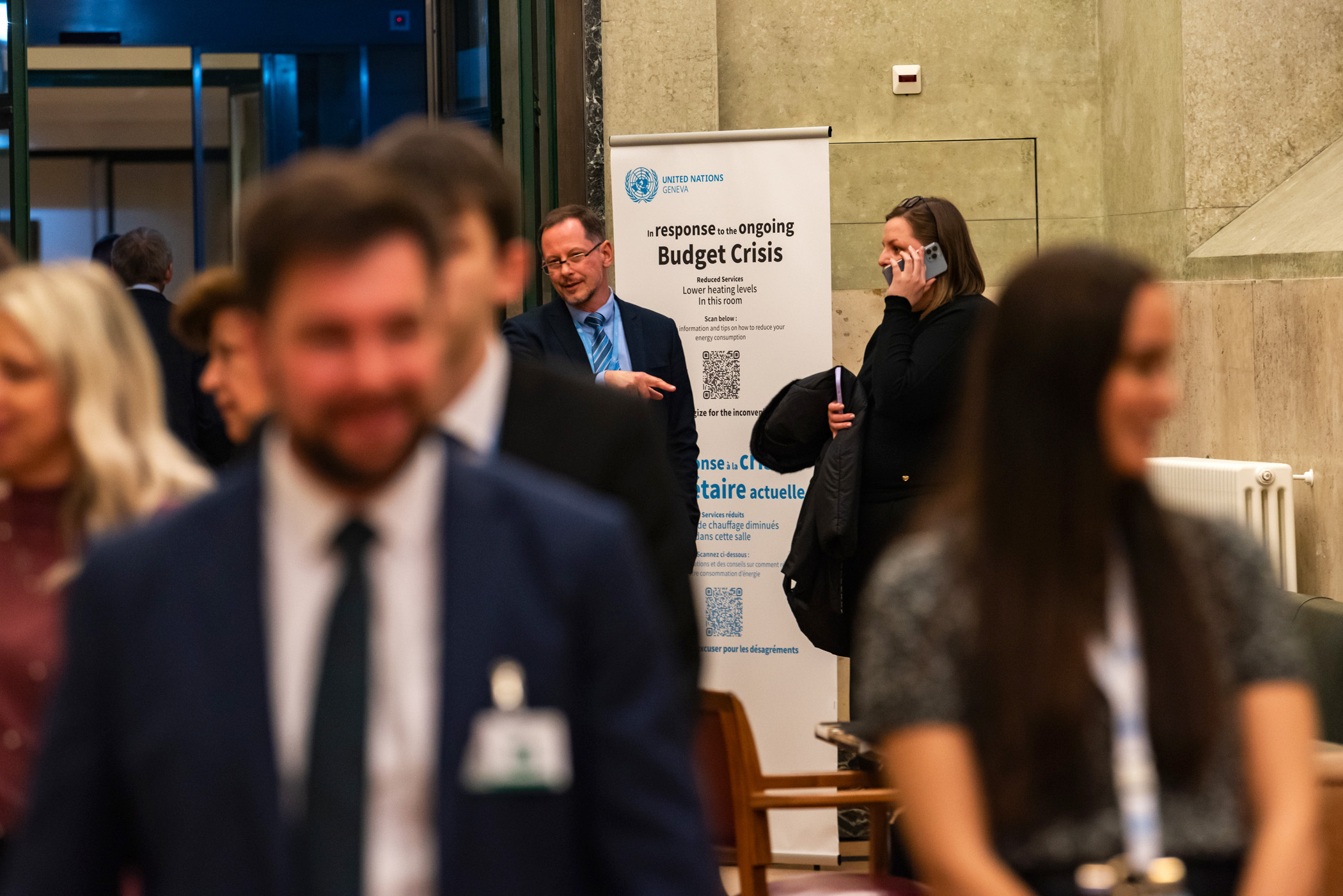 Konferenzteilnehmer:innen und ein Poster in einem Korridor