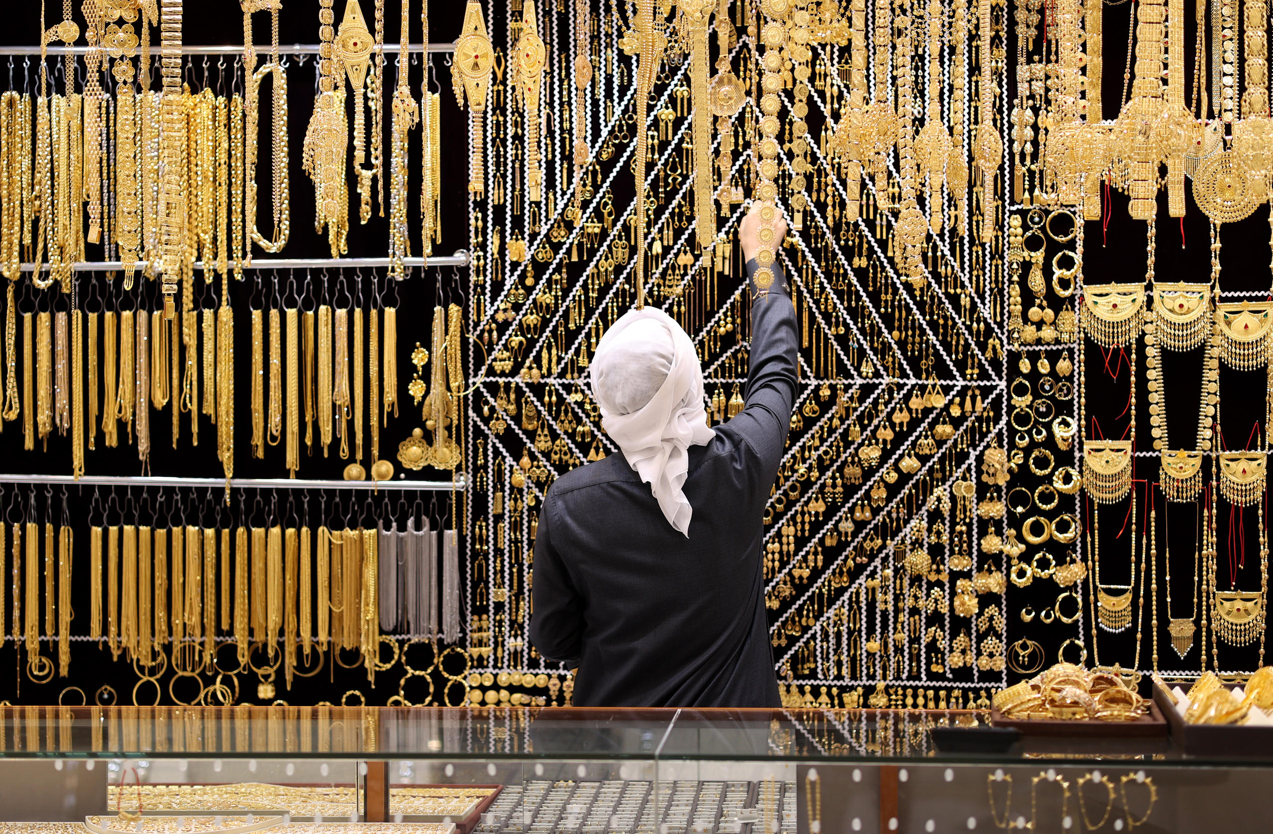بائع يرتب المجوهرات الذهبية في سوق الذهب في دبي.