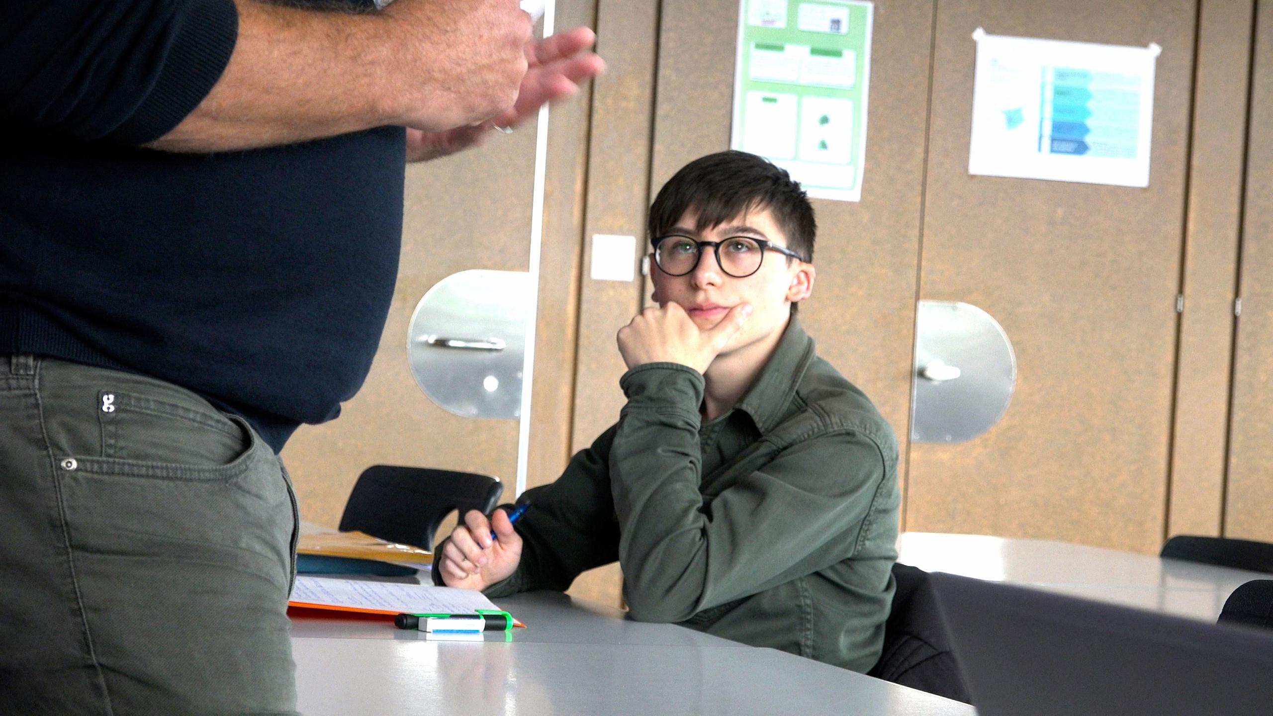 Amato Pace sitzt im Schulzimmer an einem Pult