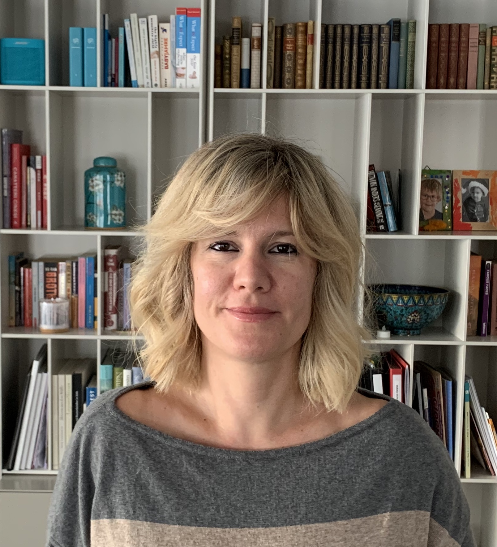 Femme posant devant une bibliothèque