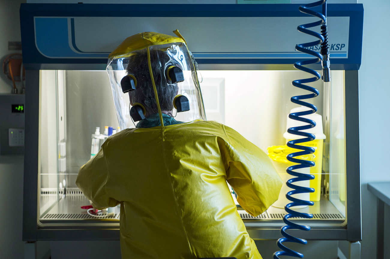 Person in einem gelben Schutzanzug im Labor Spiez in Bern