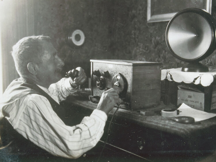 Mann hört ein Radio aus dem frühen zwanzigsten Jahrhundert