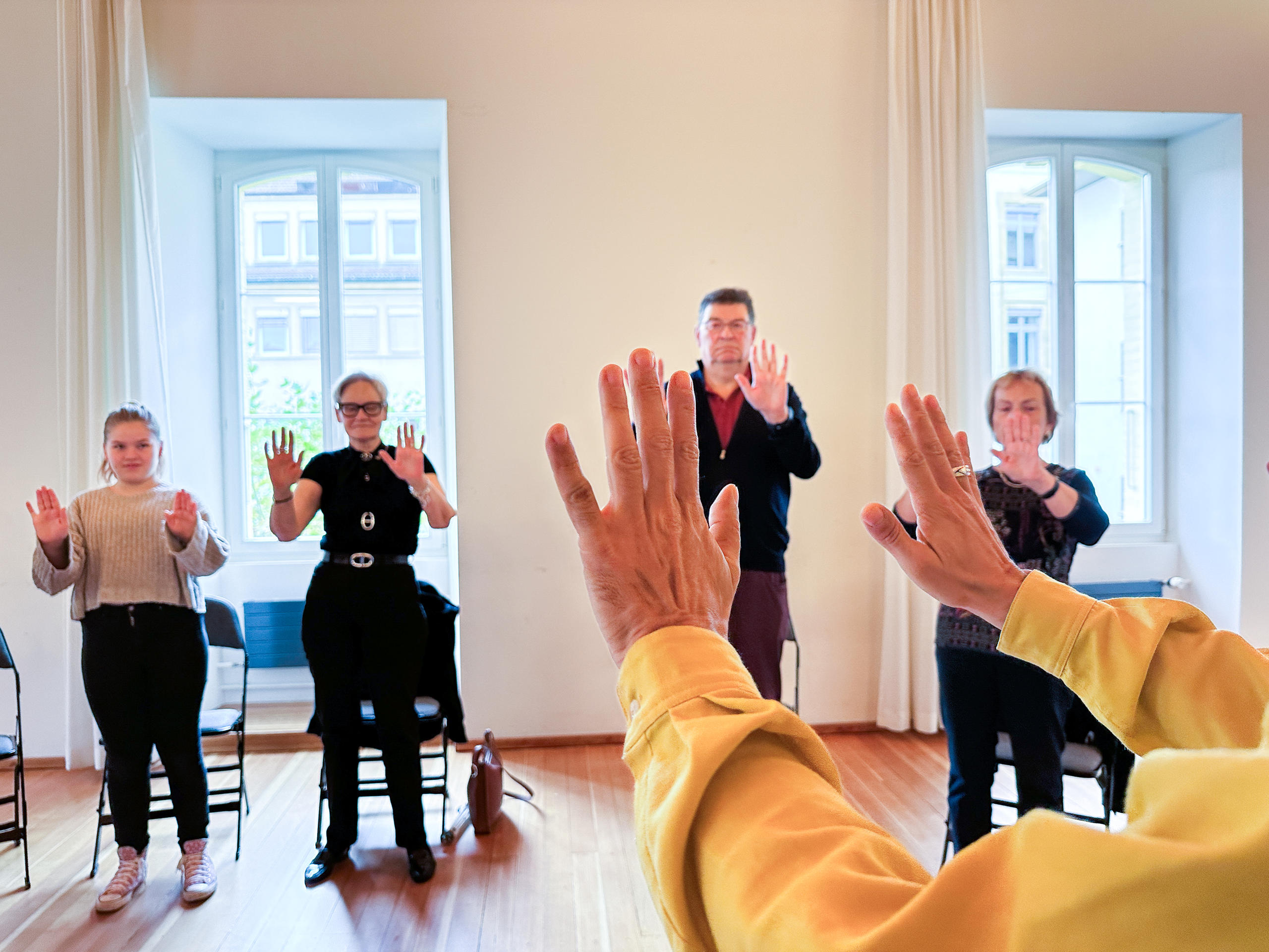 A group of people standing with their hands outstretched, as if resting on a pane of glass