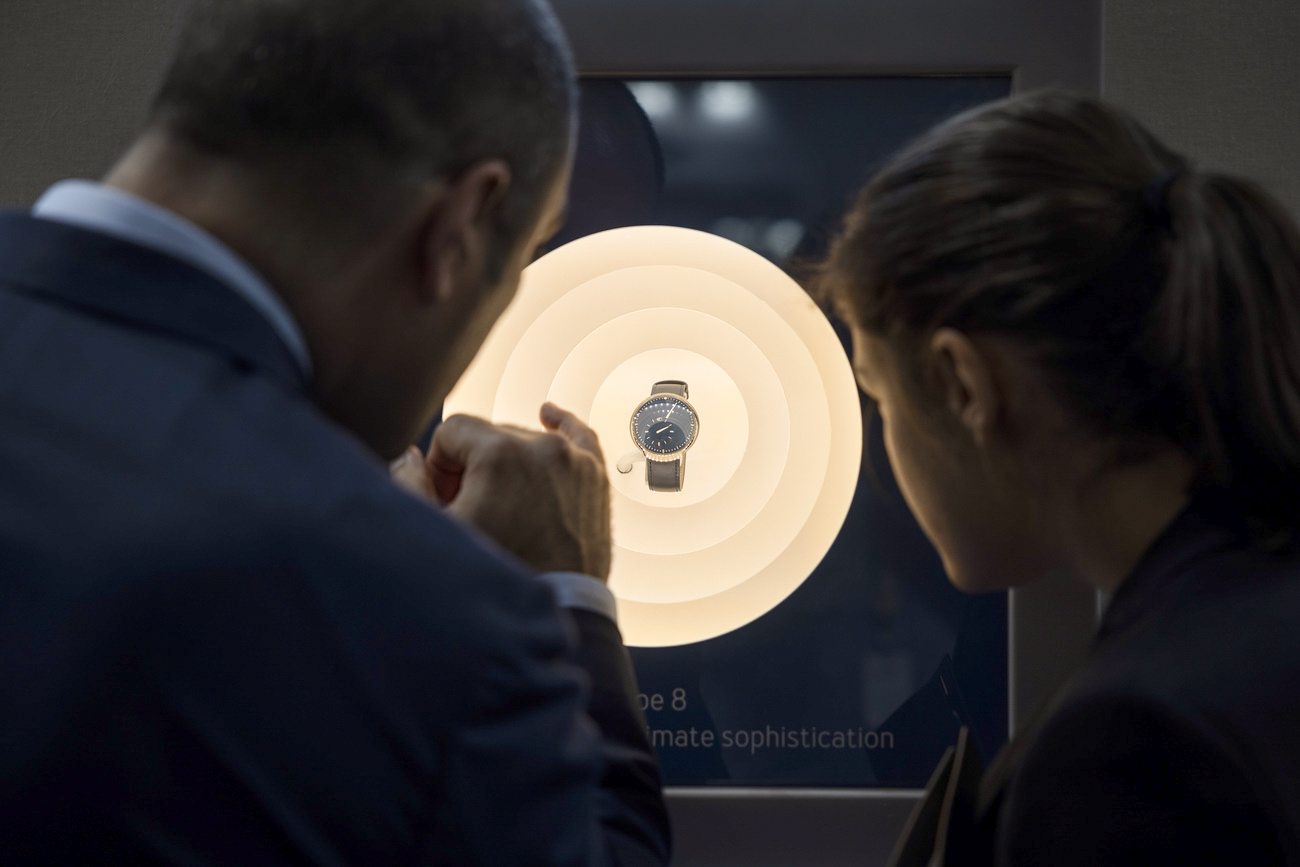 Zwei Männer betrachten eine in einer Vitrine aufwändig inszenierte Uhr