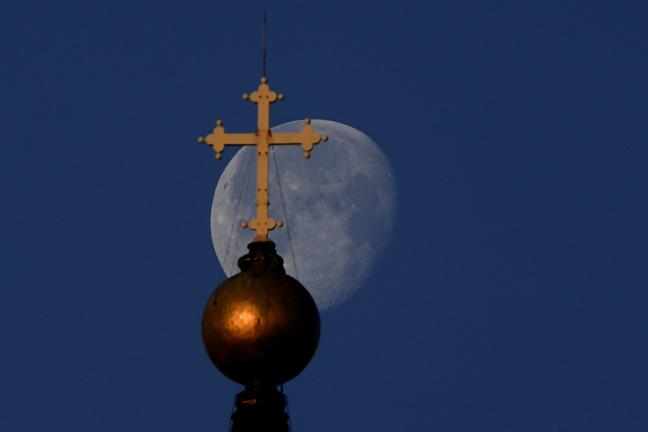 Cross of St Paul s Cathedral with moon in background
