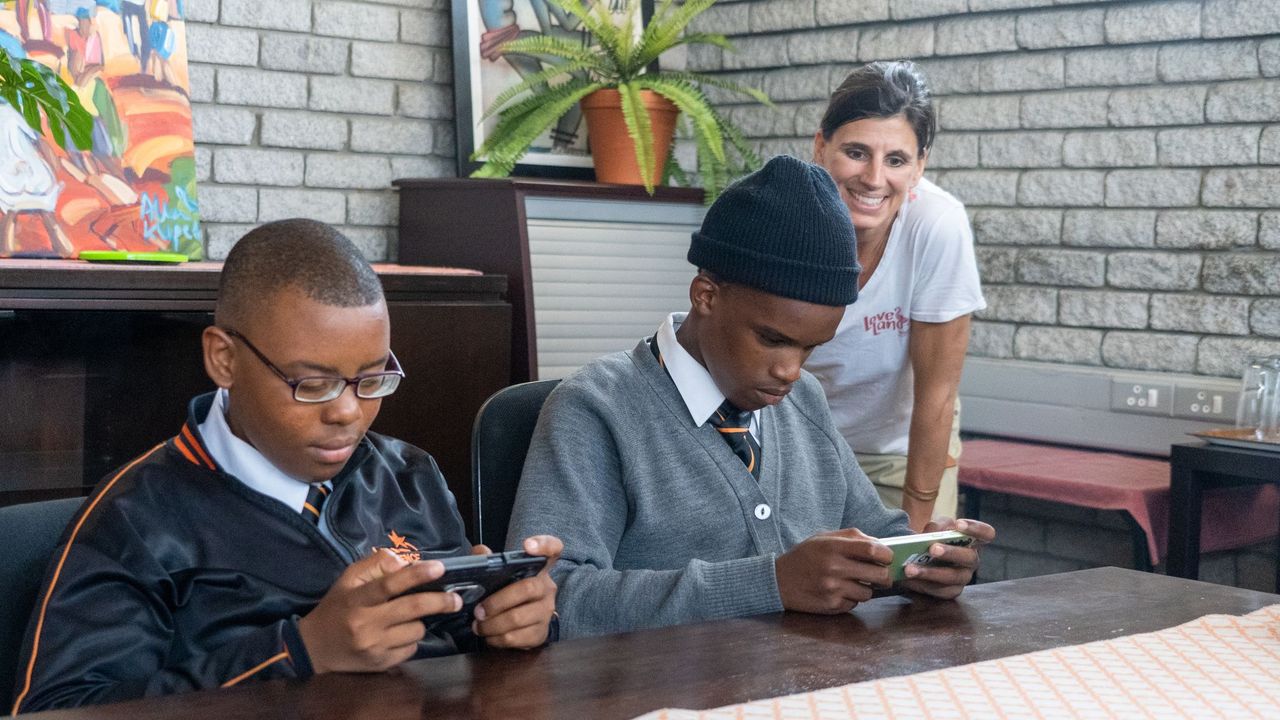 Die Schweizer App-Entwicklerin Karin Stierlin schaut in Kapstadt Schülern, die ihr Spiel austesten, über die Schulter.