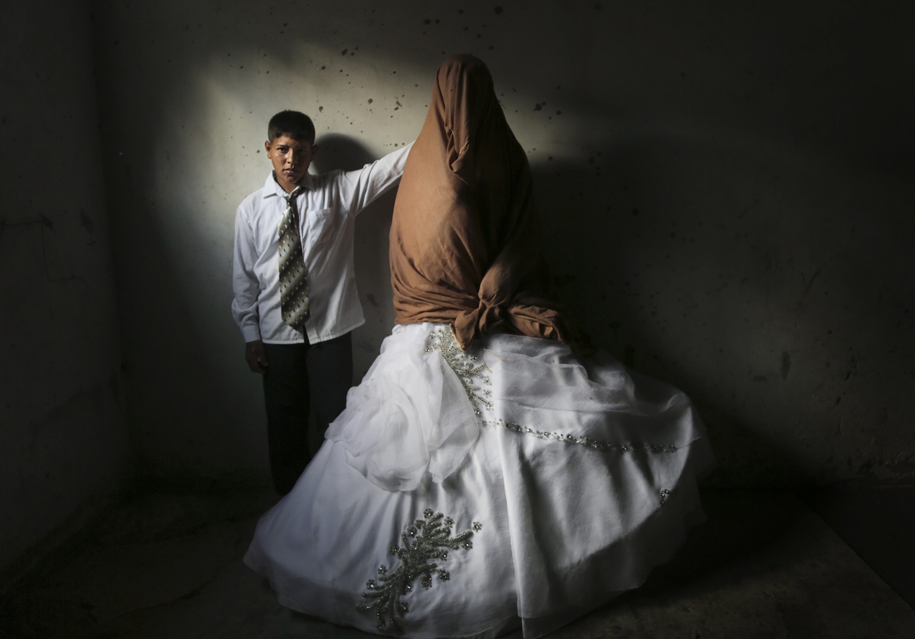 due giovanissimi sposi palestinesi (lui 15 anni, lei, di cui si vede solo la gonna del vestito, essendo il resto del corpo nascosto da un telo, 14 anni)