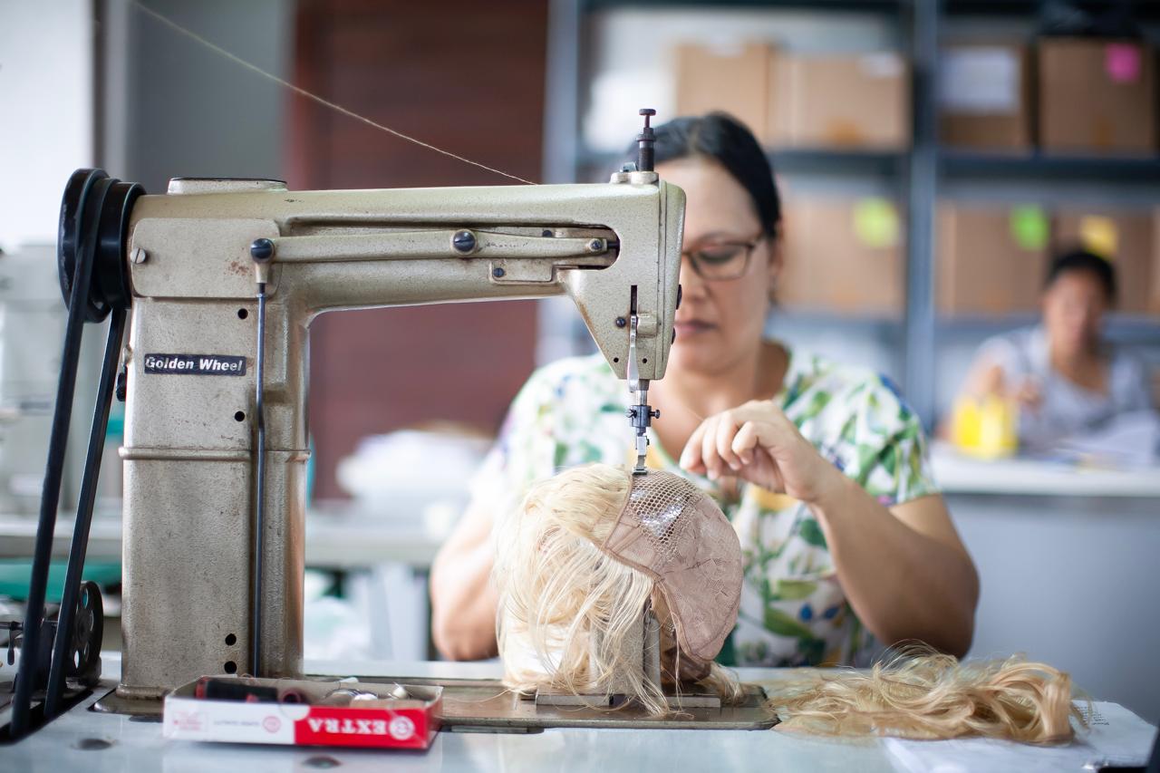 Femme fabriquant une perruque avec une machine à coudre