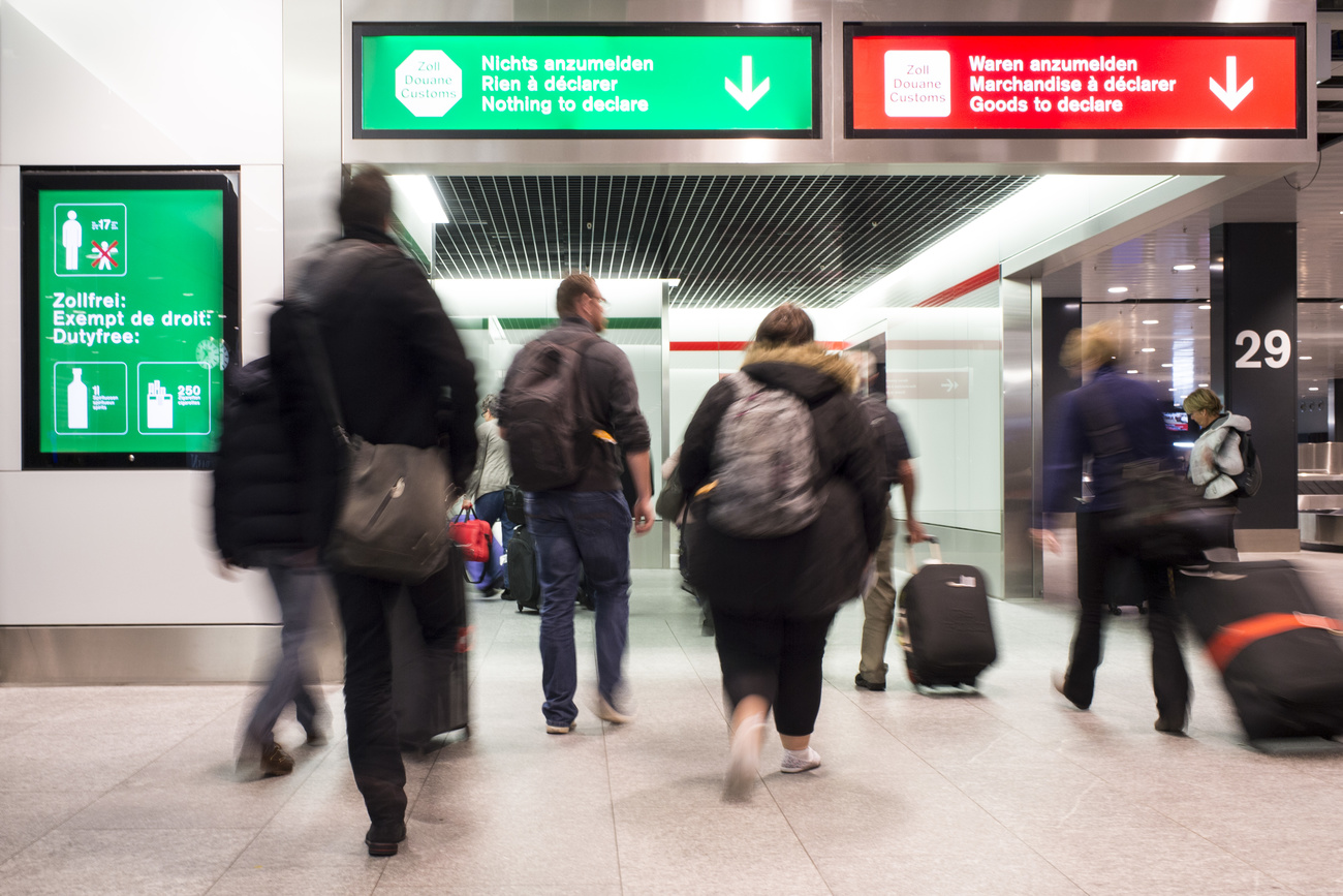 Passagier:innen passieren den Zoll am Flughafen