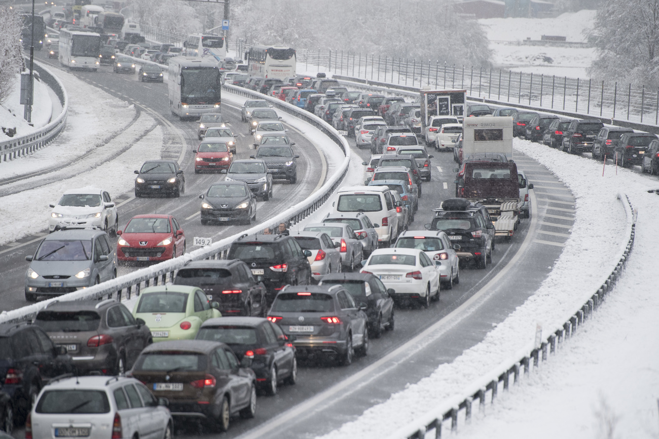 Traffico e neve al portale nord della galleria autostradale del San Gottardo.