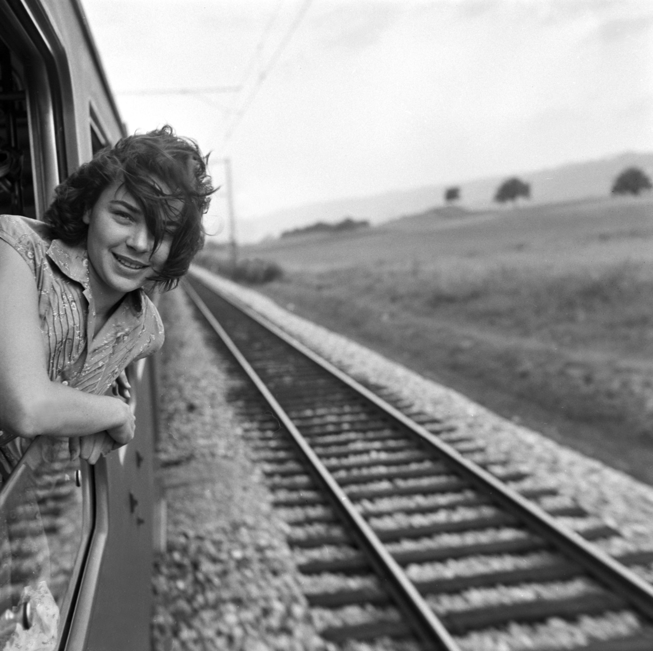 femme à la fenêtre d'un train en noir et blanc