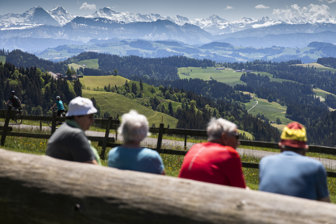 Four hikers enjoy the view of the mountains of the Bernese Alps in Luederenalp, Switzerland,
