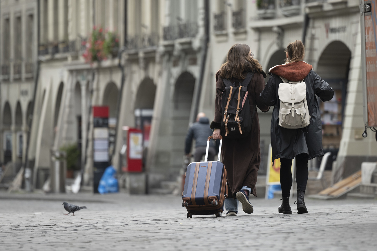 Due giovani con bagagli per le vie del centro di Berna.