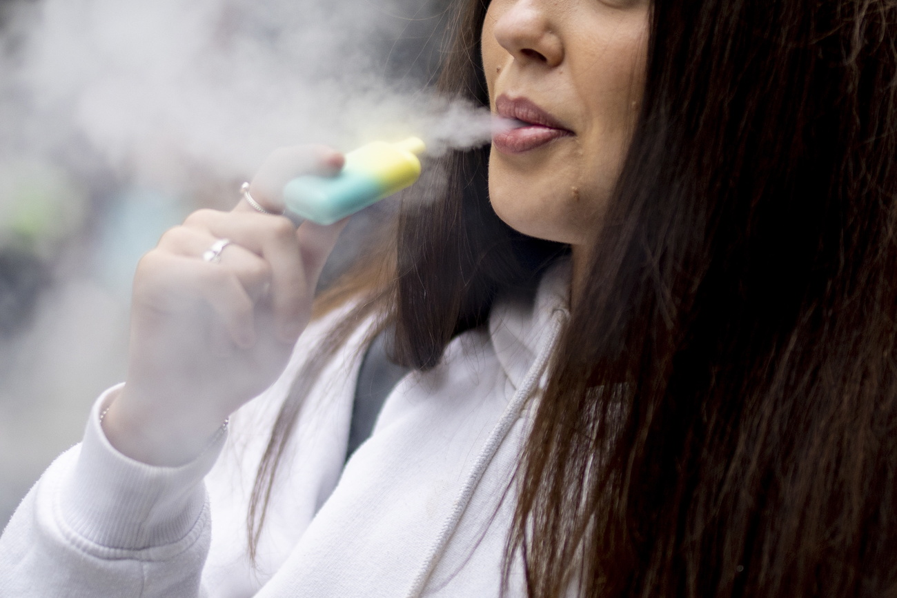 فتاة تستخدم نوع من السجائر الإلكترونية التي تستعمل لمرة واحدة، بريطانيا، 30 مايو 2023.