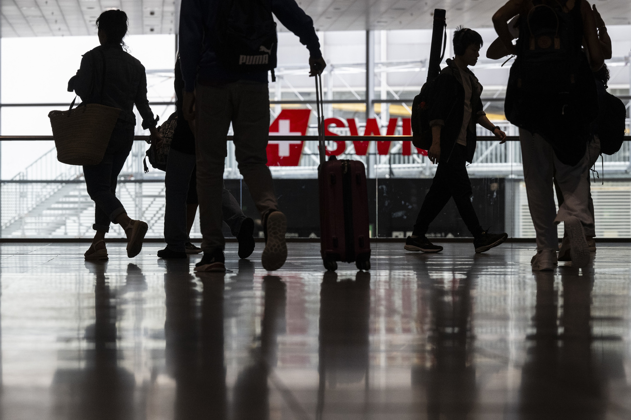 persone in controluce in una hall dell'aeroporto di zurigo