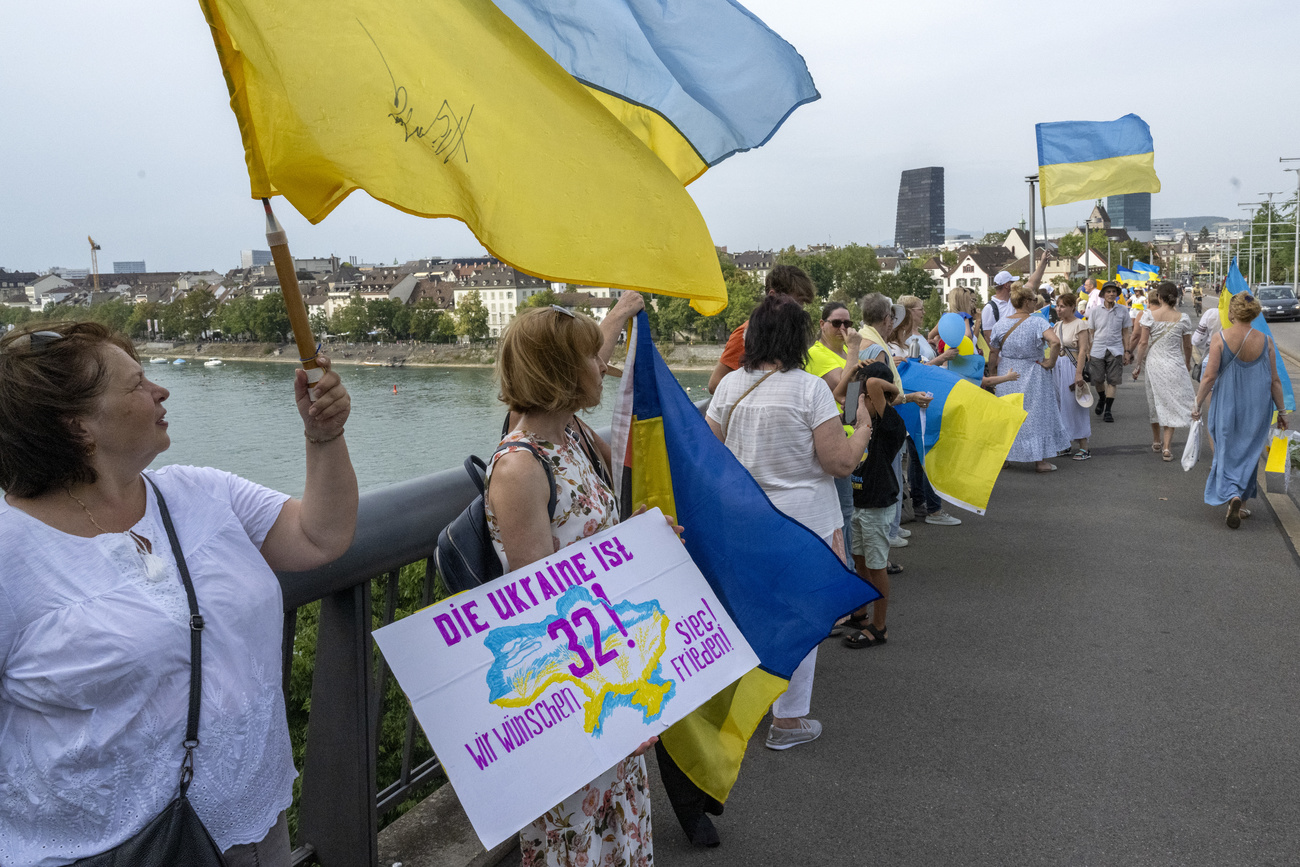 People holding up the Ukranian flag, coloured blue and yellow.